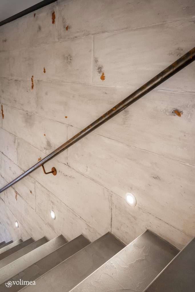 Betontreppen mit Geländer an der Wand und Beleuchtung