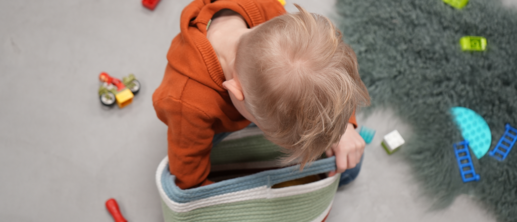 Ein Kind spielt mit Lego-Bausteinen auf dem Futado-Boden.