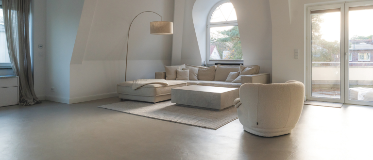 Ein minimalistisches Wohnzimmer mit einem grauen futado Boden von Volimea.