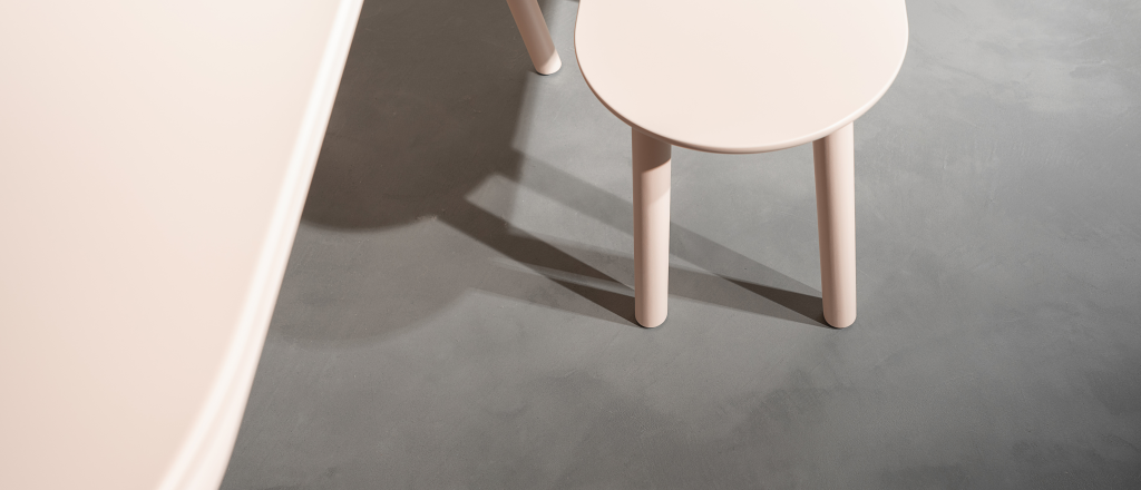 Ein heller Holzstuhl auf einem dunkel-grauen, fugenlosen futado-Boden von Volimea.